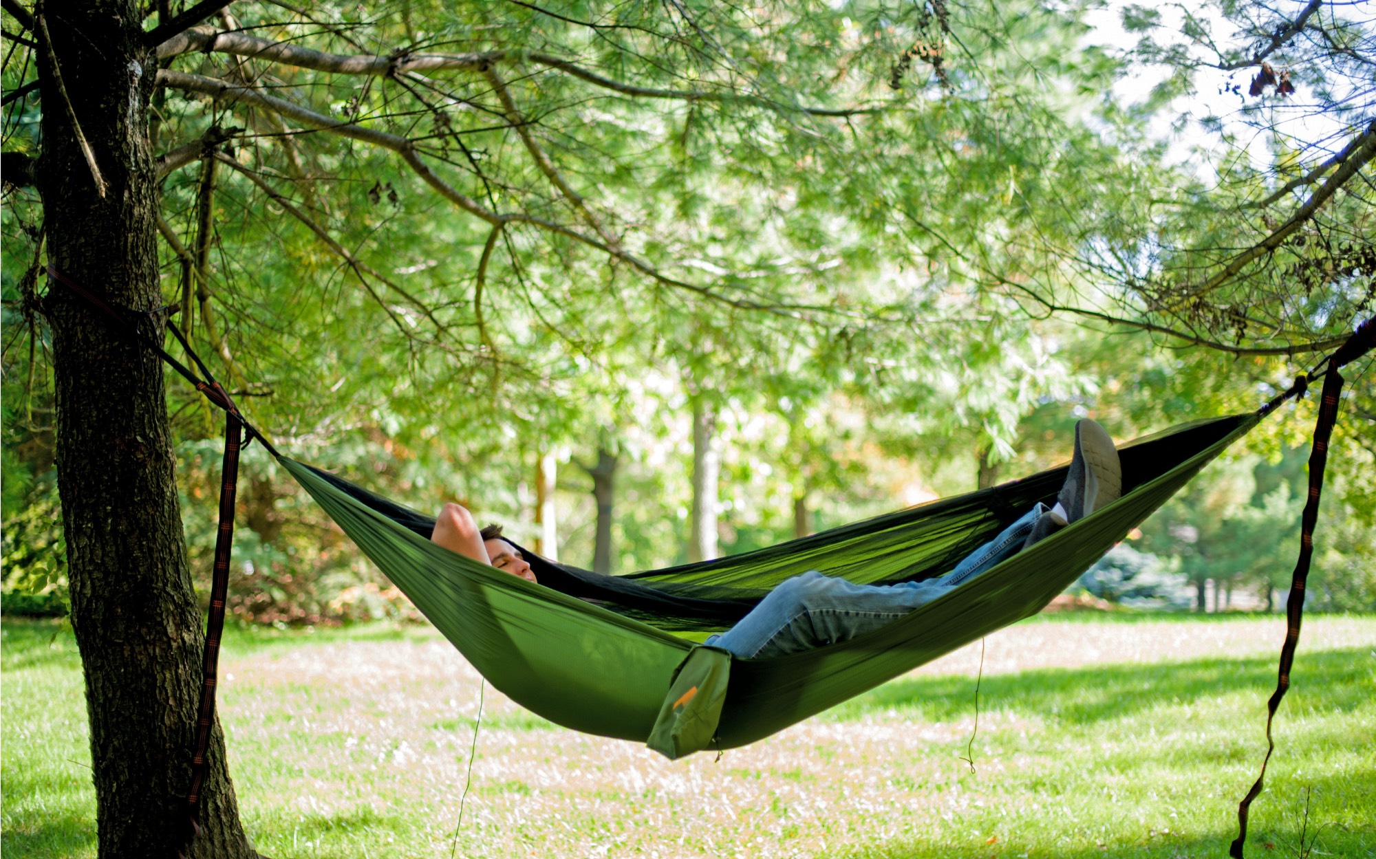 Student relaxes in hammock on campus